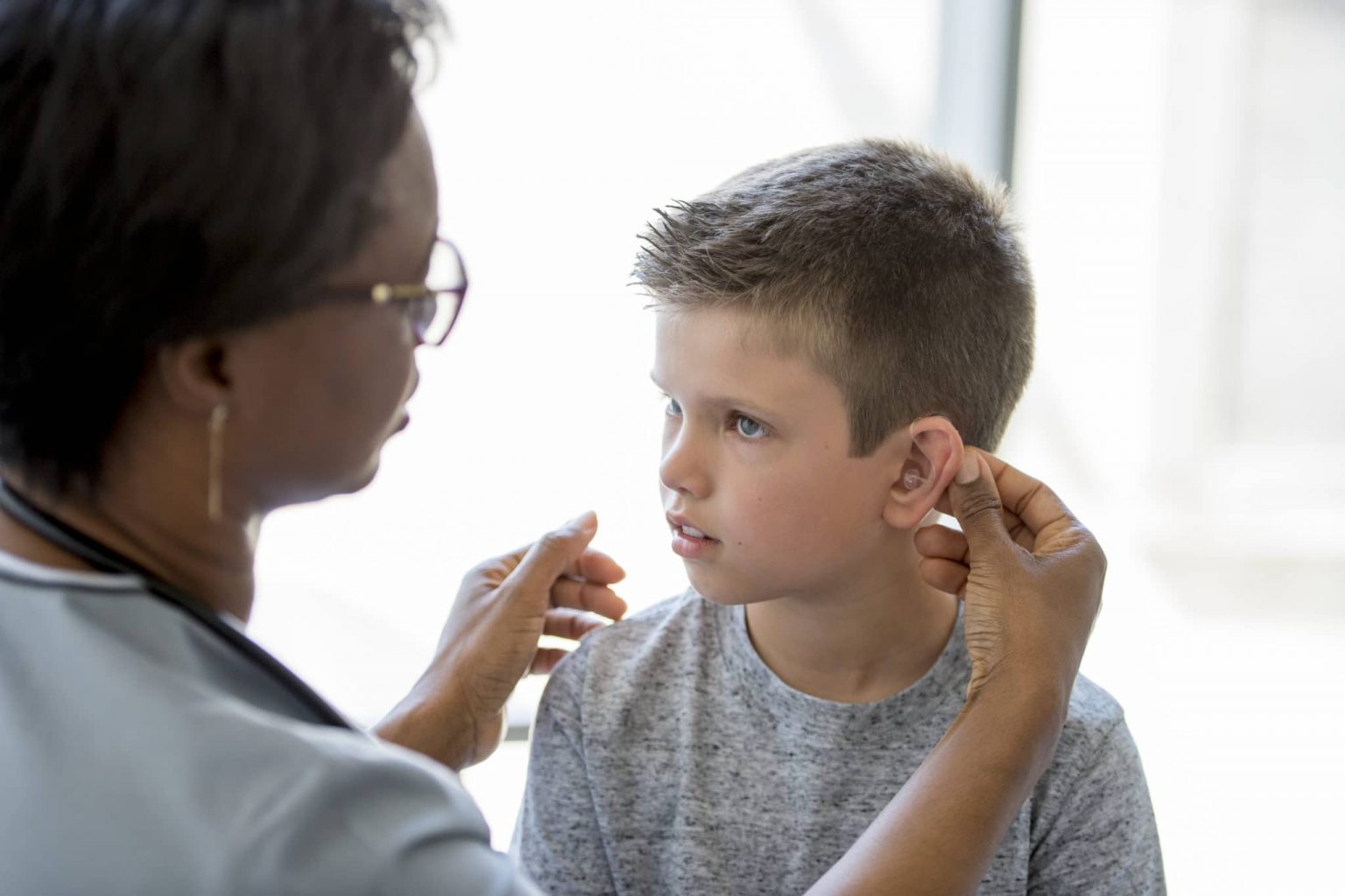 Child With Hearing Aid Receiving Hearing Checkup From Audiologist