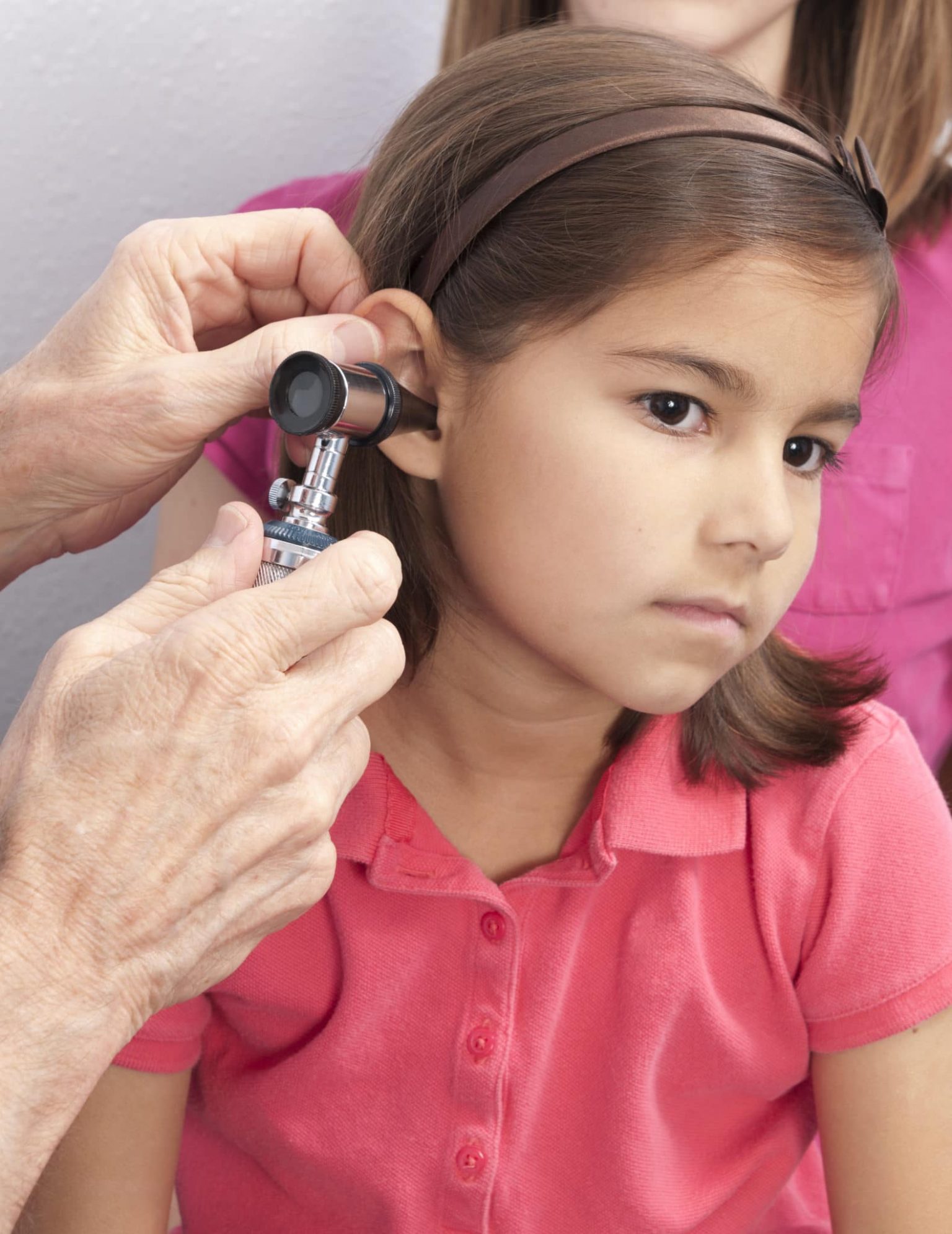 pediatric-ear-infection-symptoms A young female patient being examined for an ear infection.